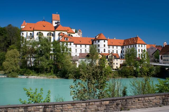 Das Rathaus mit Verwaltung und Museum von Füssen vom Lech aus gesehen