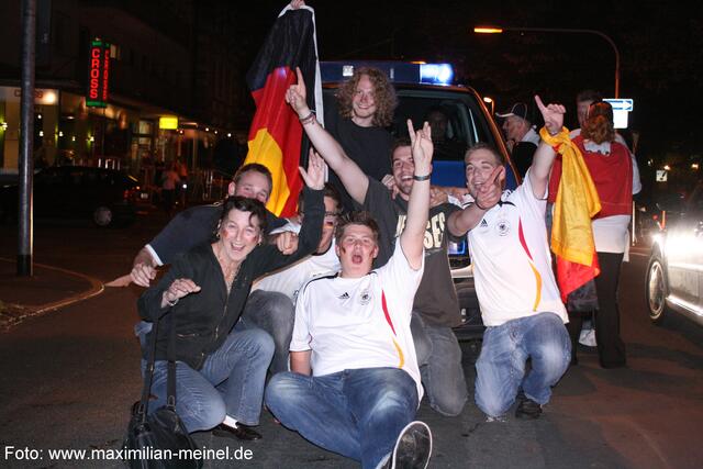 Fans vor einem Polizeiwagen.