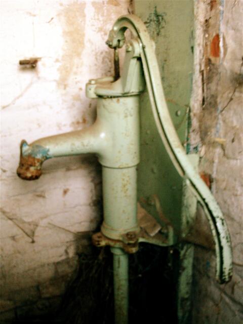 Wasser-Pumpe im Gang zwischen Haus und Stall