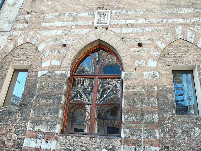 Im Fenster des Opedale di Santa Maria della Scala spiegelt sich der Dom
