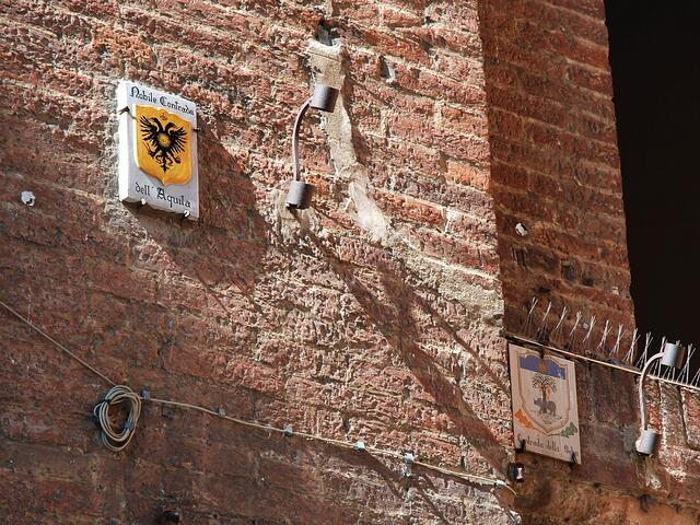 Schilder weisen den Weg in die Contrada