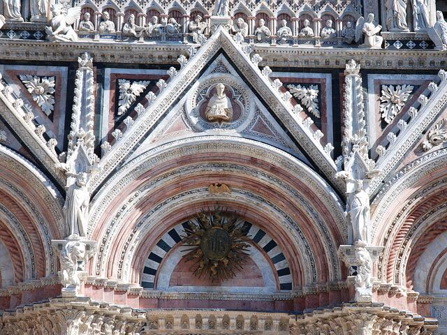 Kunstvolle Steinmetzarbeiten verzieren die Fassade des Doms zu Siena