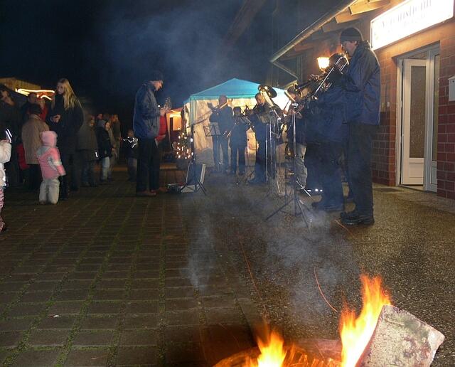 Feuerkörbe verbreiteten Licht, Wärme und Rauch. Im Hintergrund das Blasorchester Dollbergen.