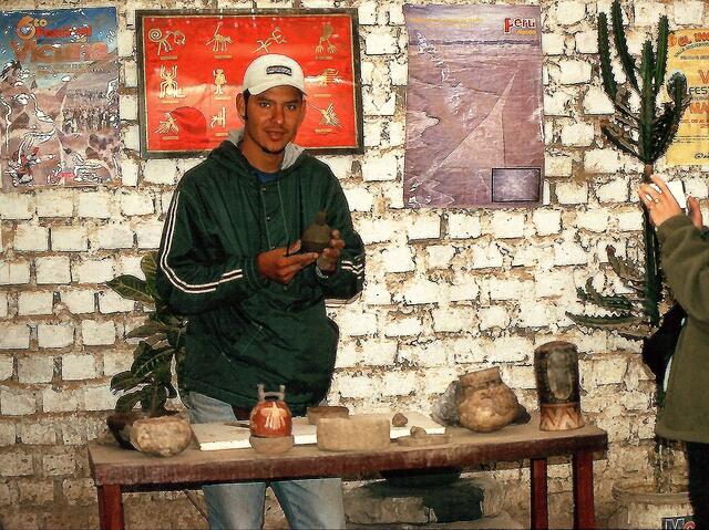 Claudio empfängt uns und erzählt die Geschichte der Töpferei in der Nazca Kultur. Vor ihm stehen Tonbehälter aus alter Zeit.