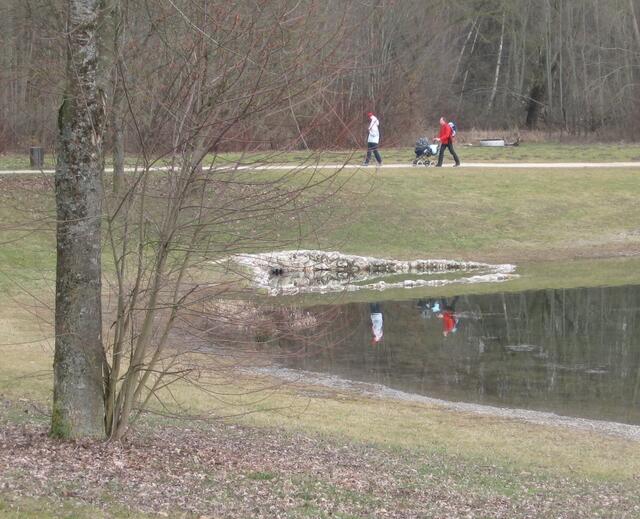 die kleine Familie wandert zügigen Schritts um den See