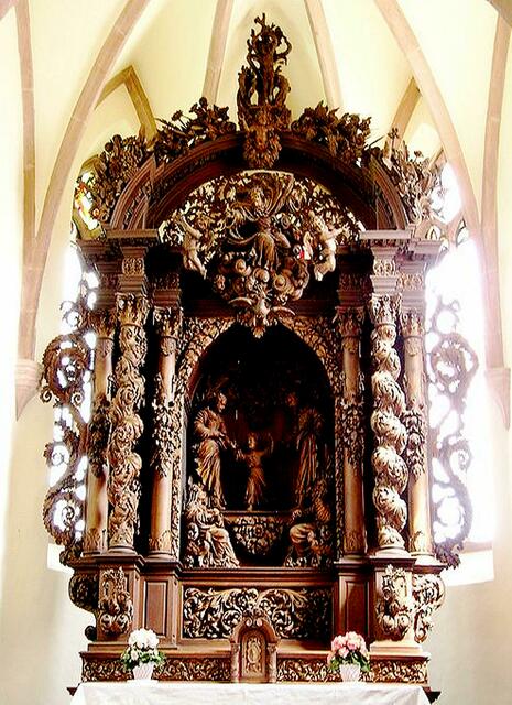 man kann an ihm die heilige Familie in einer Fülle von Blumen, Früchten, Trauben und Maria in ihrer elsässischen Tracht aus dem 17. Jahrhundert bewundern. | Foto: http://de.wikipedia.org/w/index.php?title=Datei:Autel_de_la_Chapelle_Saint-Sebastien_de_Dambach-_la-Ville.jpg&filetimestamp=20070327213256