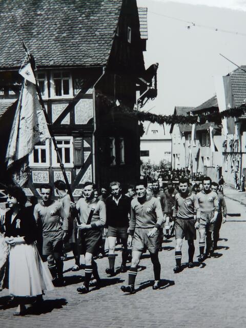 Festumzug 1959: Fußballer der SG Fronhausen. Blick auf das Fachwerkgebäude Bahnhofstraße Nr. 1; noch mit Kratzputz. Siehe Artikel von W.H. zu Kratzputz in Fronhausen: myheimat-BEITRAG