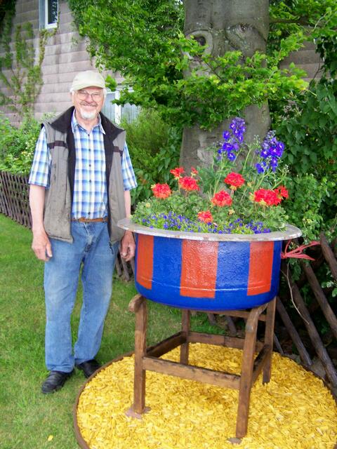 Karl Warnstorf vor seinem wunderschönen blau/roten Blumenkübel