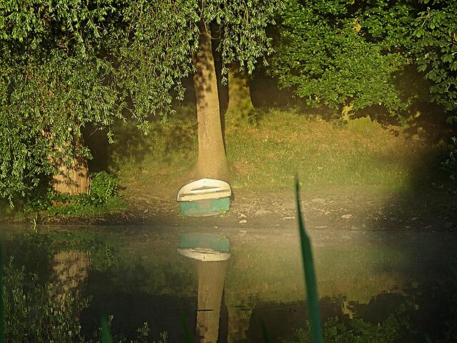 Die Frühsonne fängt mit ihren ersten Strahlen ein Boot ein