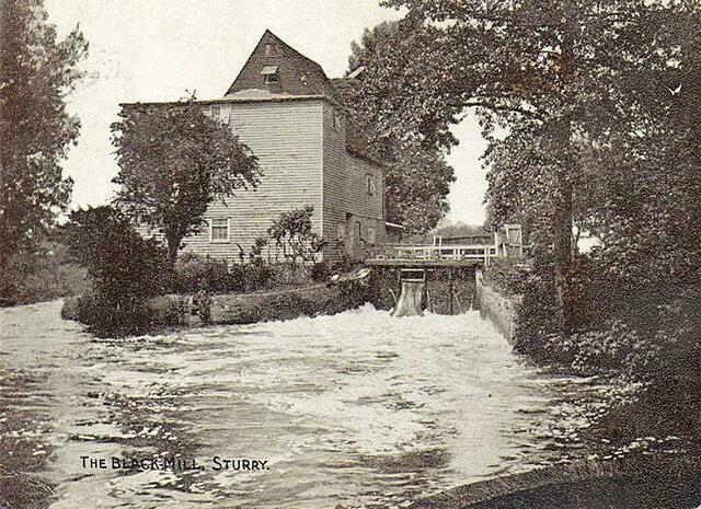 In der Nähe, am Fluss, ist eine große Wasser-Mühle,