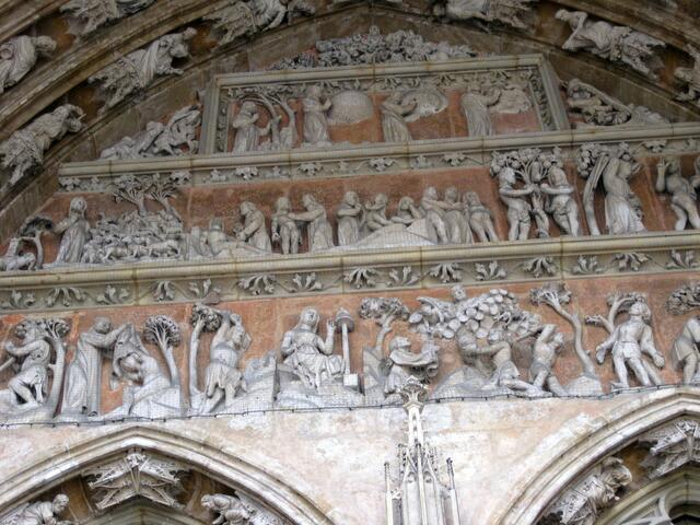 Das Bogenfeld über den Türen erzählt von der Erschaffung der Welt und vom Sündenfall. Vom Ursprung her auf das Ziel zu führt der Weg dieser Kirche, die von Westen nach Osten ausgerichtet ist.