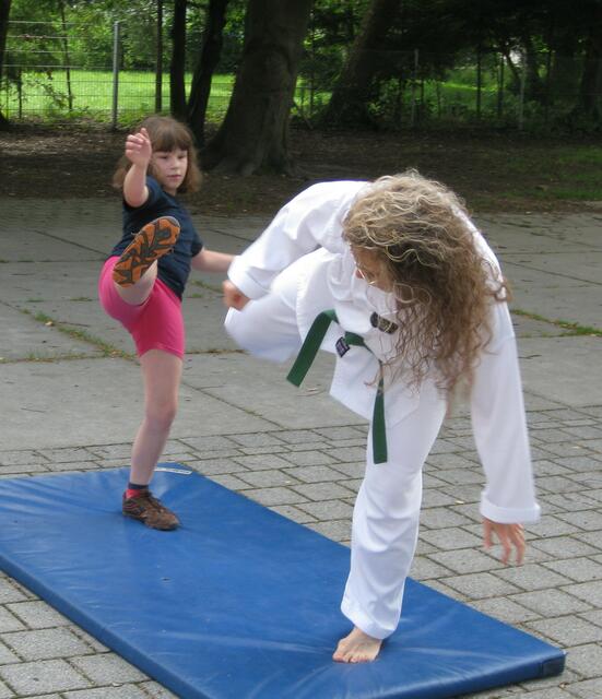 Gleichzeitiger Rundkick zum Bauch mit einer Schülerin