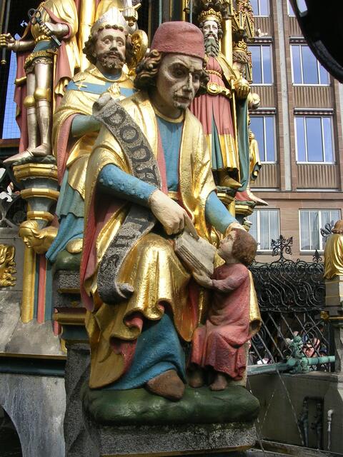 In vier Reihen stehen vierzig Steinfiguren, allesamt bedeutende Werke des 14. Jahrhunderts, die das Weltbild des Heiligen Römischen Reiches repräsentieren: unten die Allegorien der Philosophie und der Freien Künste,