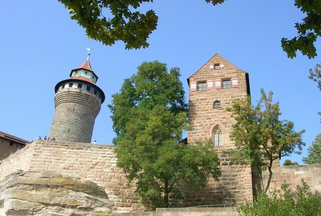 Hoch über der Stadt thront das Wahrzeichen Nürnbergs, die Kaiserburg. Die Burg, in der von 1050 bis 1571 alle Kaiser des Heiligen Römischen Reiches zeitweise residierten, gehört zu den bedeutendsten Kaiserpfalzen des Mittelalters.