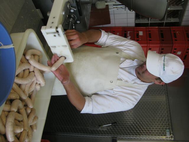 Metzger an der Spritze. Immer gleiches Gewicht und Größe der Weißwürste.