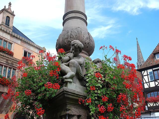 Vor dem Rathaus sitzt dieser kleine Musiker auf dem Brunnen.