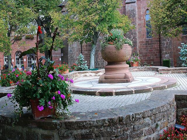 Brunnen und Blumen im Innenhof der Klosteranlage.
