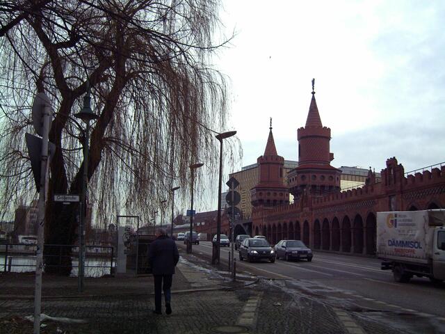 Die Weide mit der gläsernen Tafel. Viel Verkehr auf der Brücke.