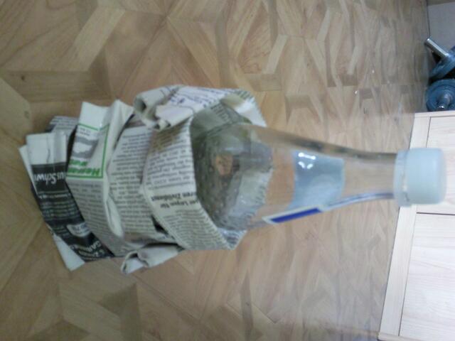 Man wickelt die Flasche,wie auf dem Bild zu sehen damit ein!(Am besten man tackert die Enden zusammen,damit es besser hält)