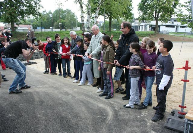 Kinder unterstützen Bürgermeister Vollmer bei der offiziellen Freigabe des Spielplatzes und können Reportern bei der Arbeit zusehen