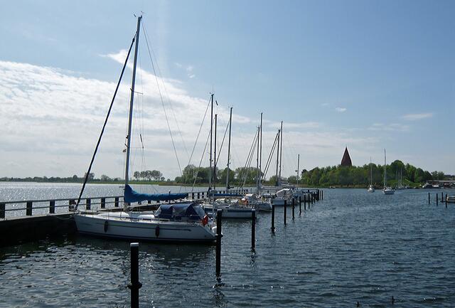 Marina in Niendorf, im Hintergrund die Ortskirche, umgeben von Wallanlagen