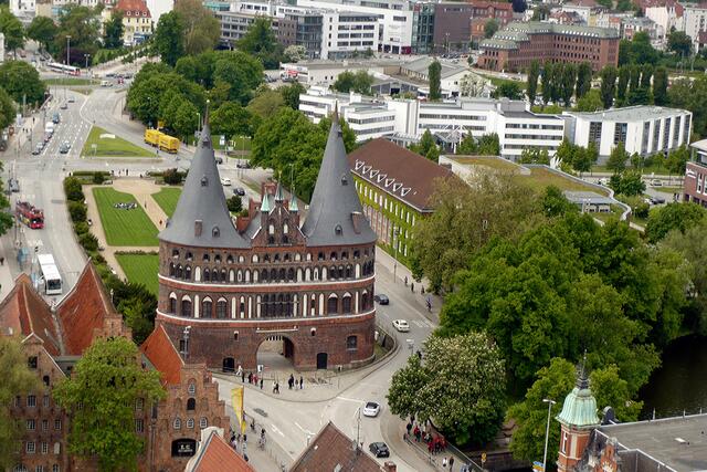 Die Kegel mit den Giebeln zwischen den Rundtürmen sind die markanten Formen des denkmalgeschützten Gebäudes, das weithin bekannt ist. Lübeck ist seit 1987 Weltkulturerbestadt.