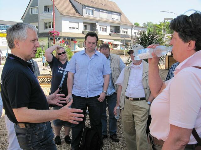 Wolfgang Weinrich erklärt, während die Besucher vom Wasser erfrischt werden.