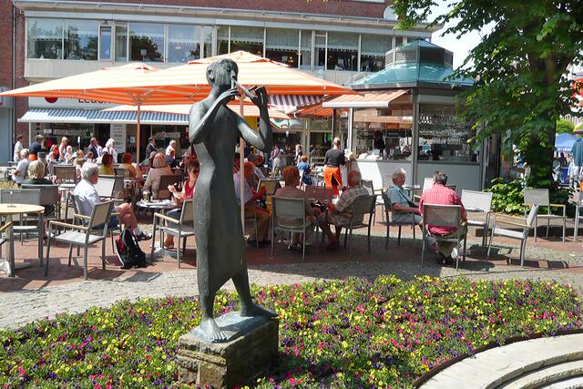 Manche meinen, die "Flötenspielerin" (von Karlheinz Goedtke, 1962) würde viele Gäste in die Straßencafés auf dem Holstenplatz locken.