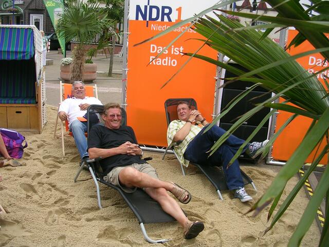 Ratsherr Karl-Heinz Köhn und Moderator Thomas Stahlberg unter Palmen am Strand