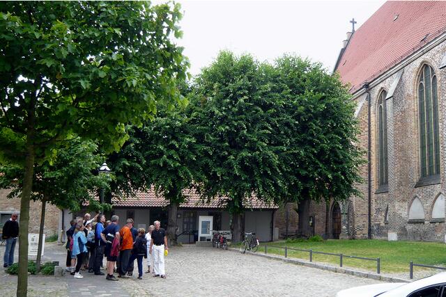 Touristengruppe vor der Universitätskirche "Zum Heiligen Kreuz"