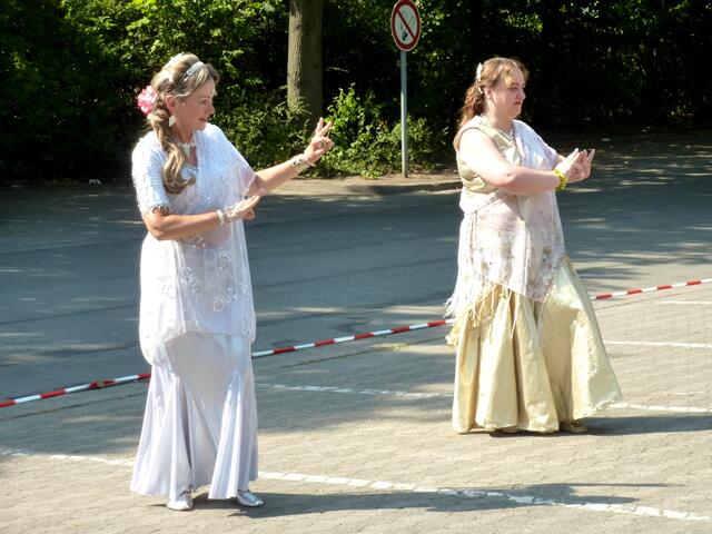 Duo Shimasira in weiß-silbernen beziehungsweise weiß-goldenen Kostümen tanzt einen indischen Tanz.