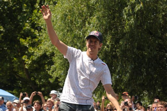 Sebastian Vettel begrüßt die unzähligen Fans am Straßenrand