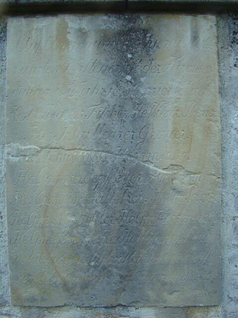 Die nunmehr 179 Jahre alte Sandsteintafel, die in den rückwärtigen Teil der Mauer eingelassen ist, kann wegen stark fortgeschrittener Verwitterung kaum mehr entziffert werden.