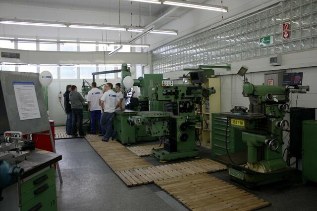 Auszubildende demonstrieren ihr Berufsfeld an den Maschinen.