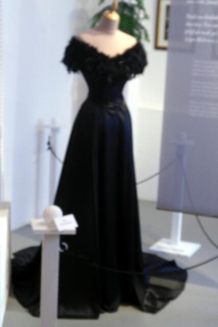 Die Mode 1898 zeigt ein tief dekolletiertes Abendkleid mit Federn