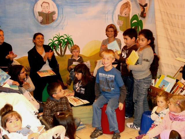 Lecture_Offenbach e.V. und Engagierte der Lese- & Erzählkarawane beim 3. Offenbacher Präventionstag. Das interessierte Publikum sitzt mittendrin. | Foto: Frank Weber