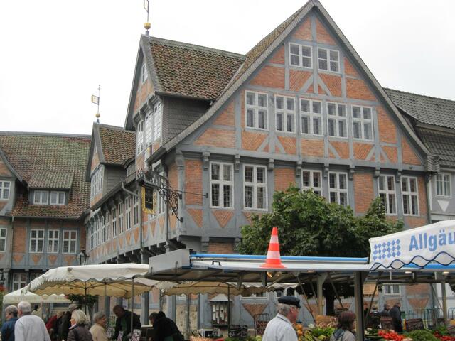 Teilansicht des alten Rathauses mit Ziegelmauerwerk und grauer Bemalung der Balken.