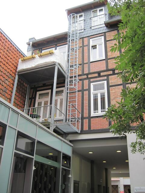 Schon kurios - die Feuerleiter endet auf einem Balkon in der ersten Etage!?