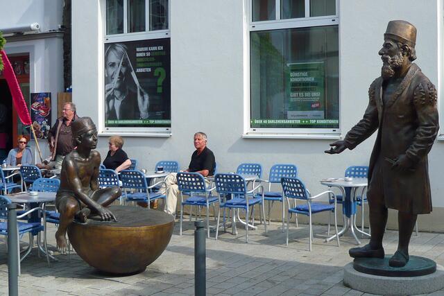 Der Rechenmeister Adam Riese blickt auf den Jungen, einen Schüler aus der Rechenschule