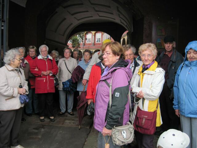 Ausflügler vor dem Eingangs-Torbogendes Wolfenbütteler Schlosses mit Durchblick auf den Innenhof