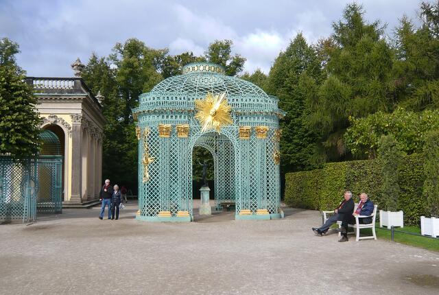 Der eingeschossige Schlossbau nimmt fast die gesamte Länge der obersten Terrasse ein. Laubengänge, die die Seitenflügel zur Gartenseite verdecken, finden ihren Abschluss in je einem freistehenden Gitterpavillon