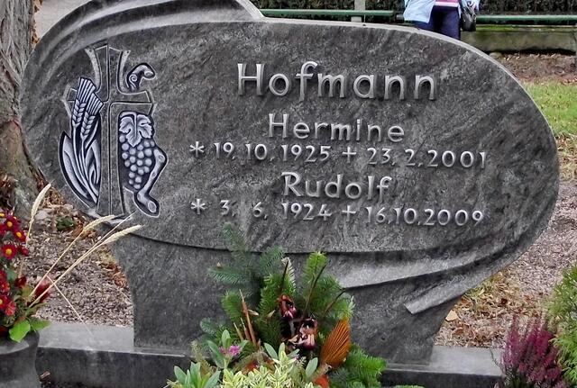 Drei Hoffnungssymbole: Das Korn, das in die Erde gelegt werden muss, der Wein, der Freude und alles hält sich am Kreuz