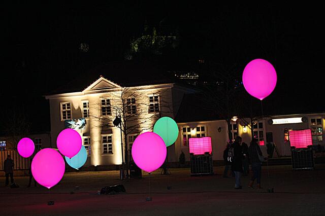 im Hintergrund ist das Schloss grün beleuchtet
