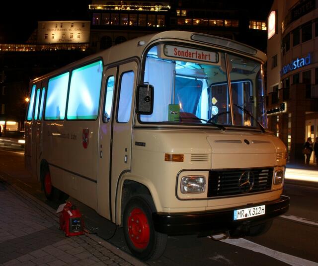 Der beleuchtete Schlossbus parkt vor dem Kino.