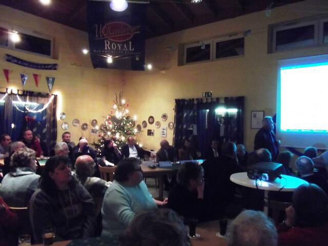 Herr Ernst stellt die auf einem Plan erstellte Statistik der Öffentlichkeit vor.