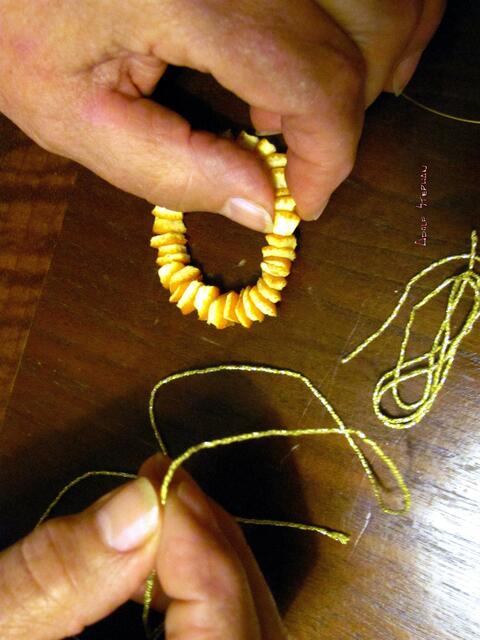 Verbindungstelle zusätzlich mit dem doppelten Hängeband zuknoten. Schleifchenschlingen in der Mitte anfassen . .