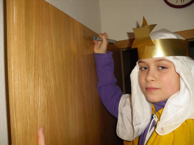 Hannah schreibt den Segensspruch "20*C+M B 11" an die Tür . . .