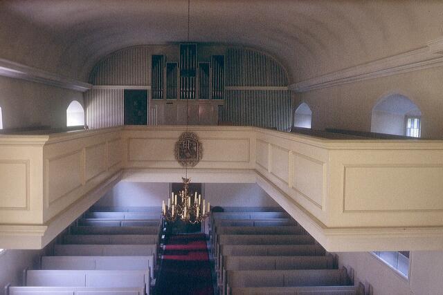 Die Sicht vom Altar zur Orgel: Die Orgelbrüstung mit einem Holzrelief von der Anbetung
