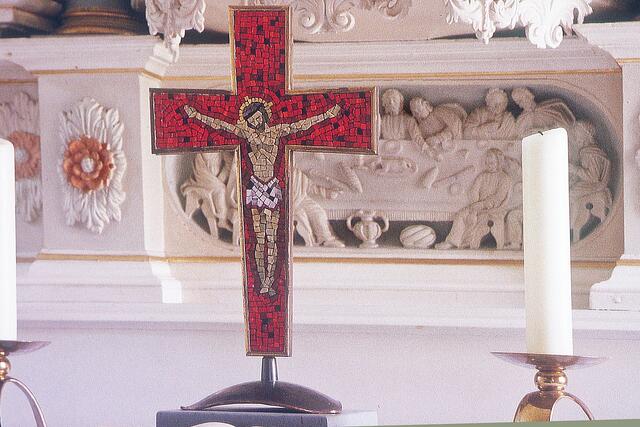 Altarkreuz, im Hintergrund die Predella mit einer geschnitzten Abendmahlsdarstellung