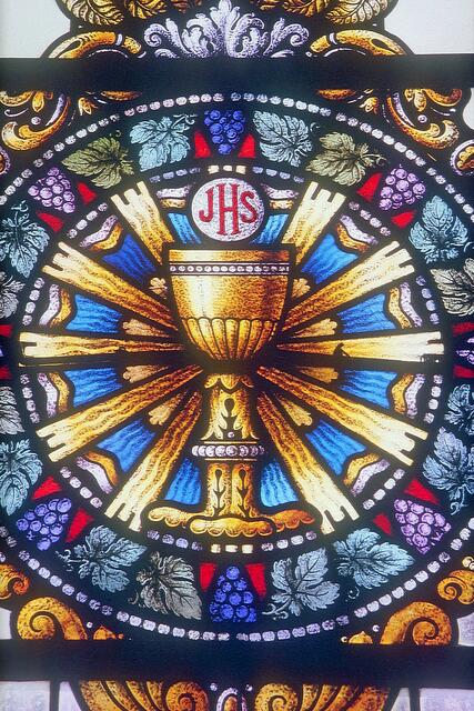 Kirchenfenster rechts neben dem Altar, Darstellung des Abendmahls mit IHS, den griechischen Anfangsbuchstaben von Jesus